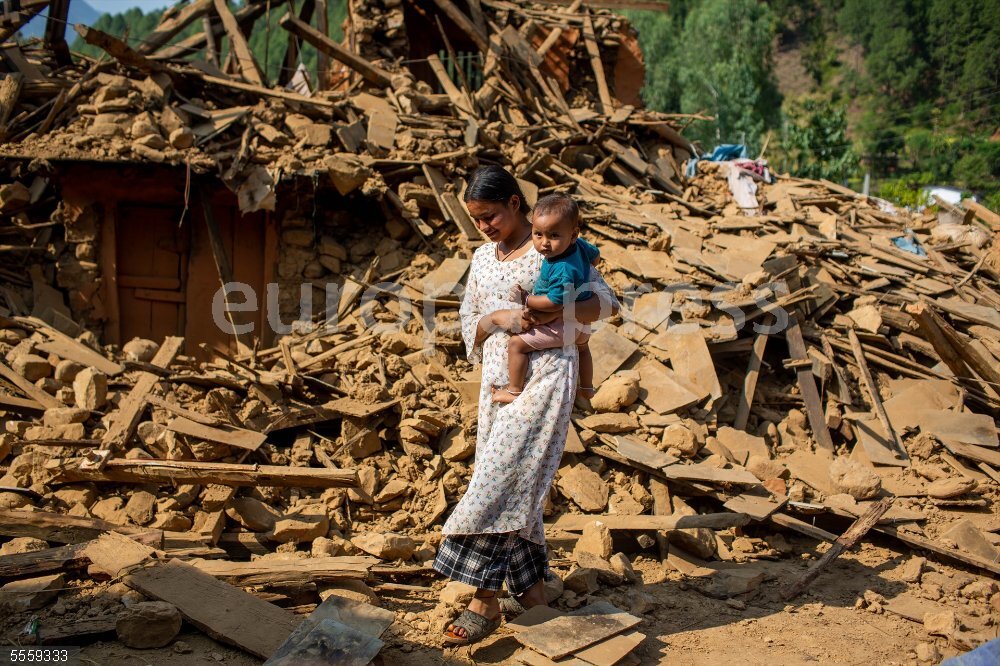 Nepal.- Guterres muestra su tristeza por los más de 150 fallecidos por un terremoto de magnitud 6,4 en Nepal JAJARKOT (NEPAL), Nov. 6, 2023  -- A woman carrying a child walks past a house destroyed in an earthquake in Jajarkot, Nepal, on Nov. 6, 2023. A total of 157 people have been confirmed dead and 349 others injured by 19:00 local time on Monday, and 17,529 houses have been found partially damaged and 17,792 others fully destroyed, according to Nepal's National Emergency Operation Center under the Ministry of Home Affairs.