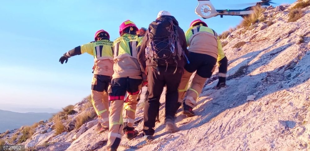 Córdoba.- Sucesos.- Bomberos de la Diputación y Guardia Civil rescatan a un senderista en el pico de La Tiñosa Bomberos de la Diputación y guardias civiles trasladan al herido al helicóptero de la Guardia Civil.