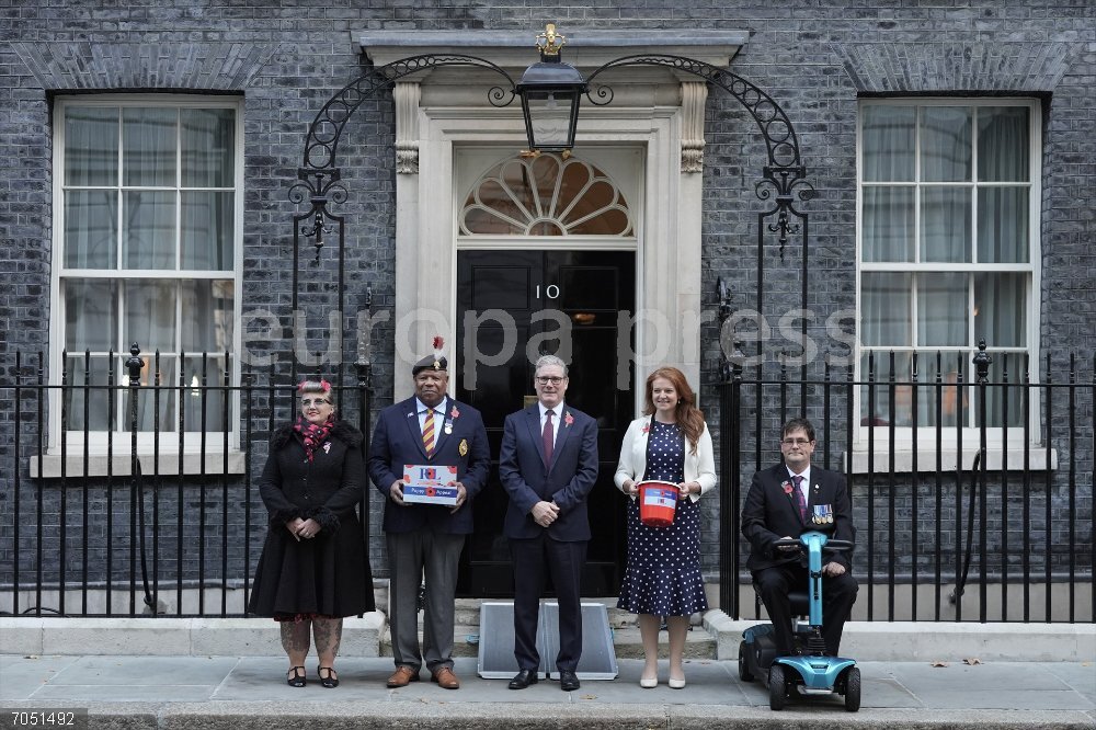 Royal British Legion Poppy Appeal 2025 24 October 2025, United Kingdom, London: British Prime Minister Keir Starmer (C) poses with members of the armed forces and volunteers outside 10 Downing Street purchasing a poppy for the Royal British Legion Poppy Appeal 2025. Photo: Stefan Rousseau/PA Wire/dpa