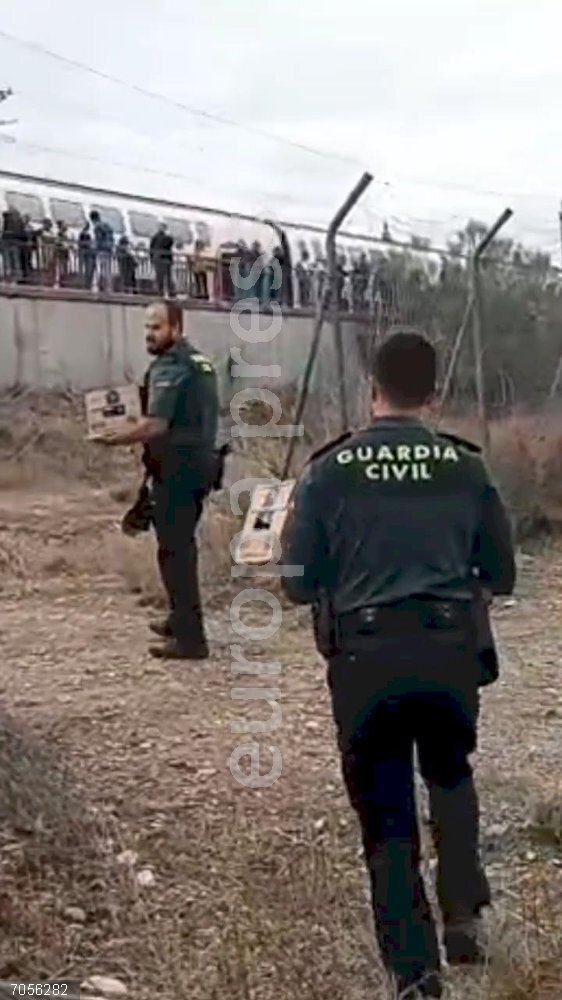Agentes de la Guardia Civil llevan agua a los pasajeros afectados por la avería de un tren de alta velocidad Barcelona-Madrid que se ha quedado parado más de tres horas en la localidad oscense de Ballobar. Agentes de la Guardia Civil llevan agua a los pasajeros afectados por la avería de un tren de alta velocidad Barcelona-Madrid que se ha quedado parado más de tres horas en la localidad oscense de Ballobar.