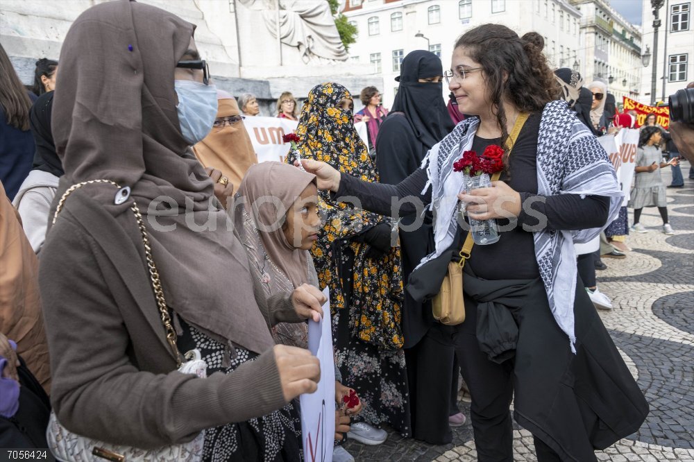 Demonstration in Rejection of The Burqa Ban in Lisbon 25 October 2025, Portugal, Lisbon: An activist hands carnations to a woman wearing burka at Rossio Square during the demonstration. Several collectives have called for a demonstration in rejection of the new Portuguese government regulation prohibiting women from wearing burqas in public spaces. With the slogan "ÄúWe are not afraid!"Äù, the organizers defend freedom of choice and condemn the advance of far-right policies. Demonstrations also seek to highlight social problems such as poor wages, homelessness, and growing inequality, calling for a free, equal, and fearless society. Photo: Jorge Castellanos/SOPA Images via ZUMA Press Wire/dpa